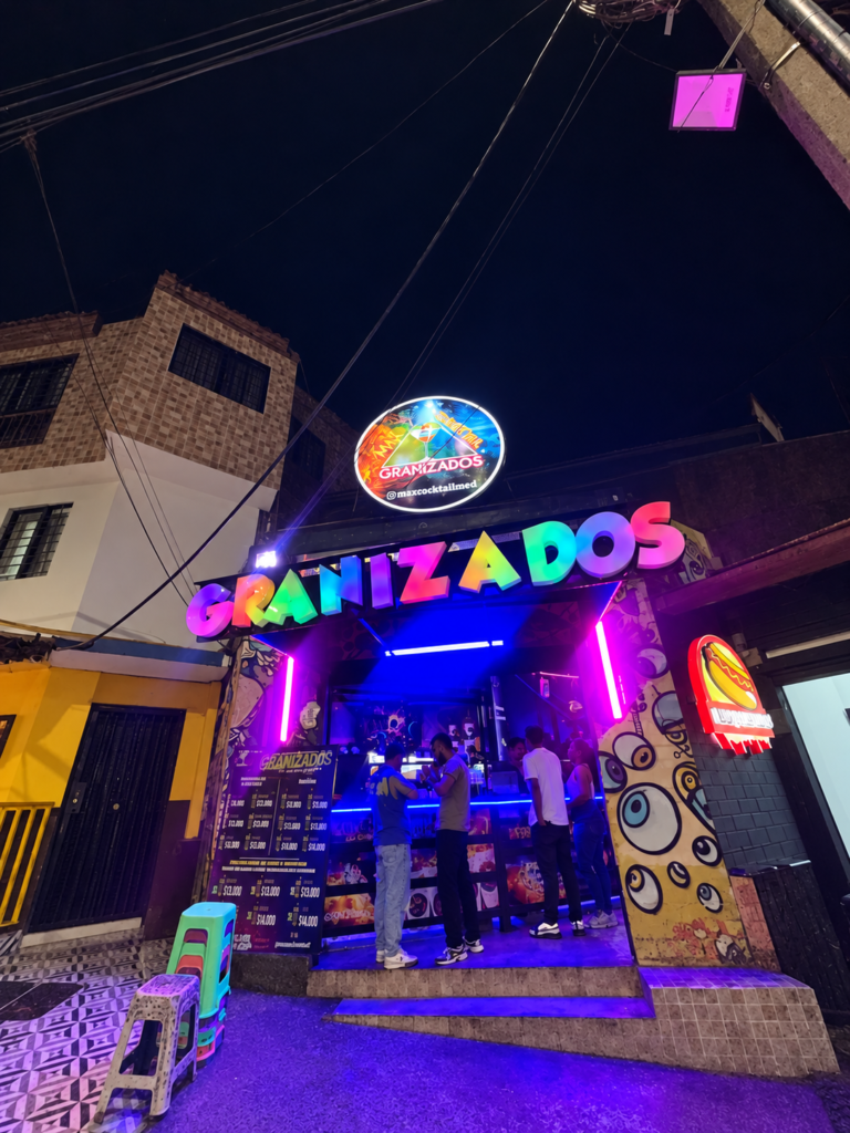 Fachada de Max Cocktail Buenos Aires en Medellín, con aviso de Granizados de colores e iluminación neón.