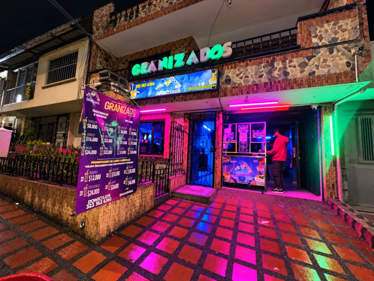 Fachada nocturna de Max Cocktail Santa Mónica en Medellín, con aviso de Granizados, entrada y luces neón.