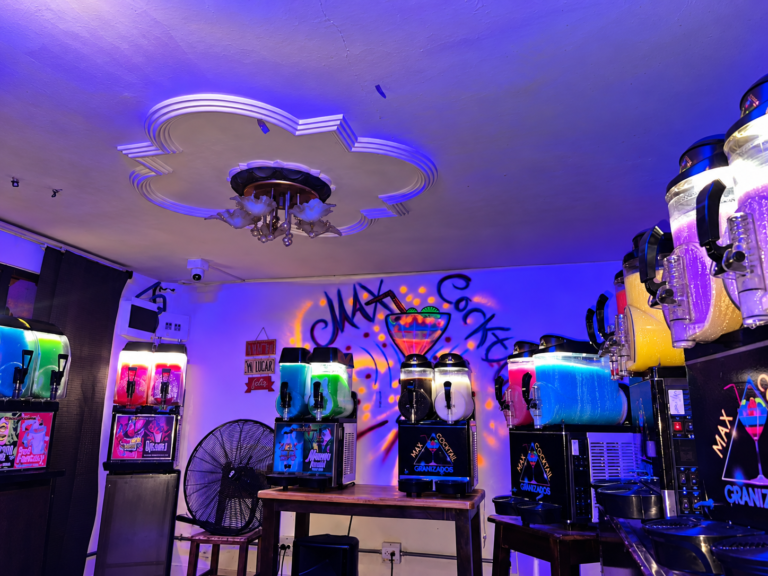 Interior de Max Cocktail Santa Mónica en Medellín con máquinas de granizados y mural de Max Cocktail.